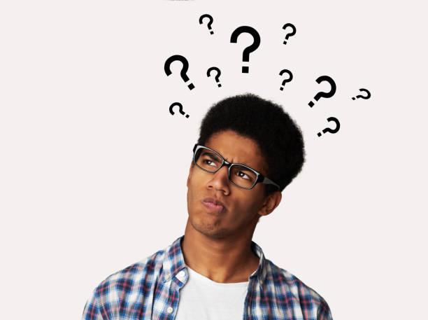 Homem preto confuso com interrogações sobre sua cabeça Confused black man with question marks over his head