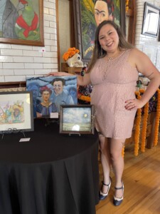 Exposição coletiva "Frida y Diego", na qual eu seguro meu quadro "Frida, Diego e os espectros" junto a outros quadros na Joslyn Castle Carriage House, Omaha, NE, EUA Ano: 2024 Eu segurando o quadro da Frida, Diego e os espectros junto com os outros quadros da exposição